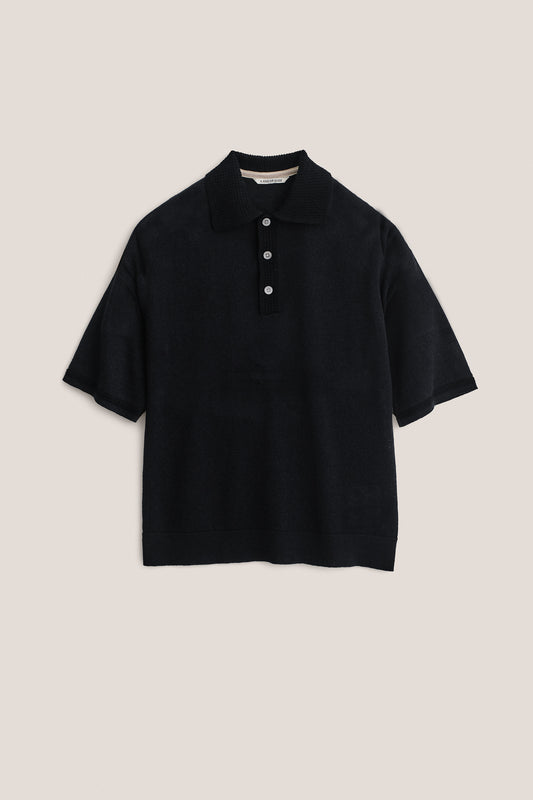 Men's knit short-sleeved polo, black linen-organic cotton blend, with spread collar and three white buttons.