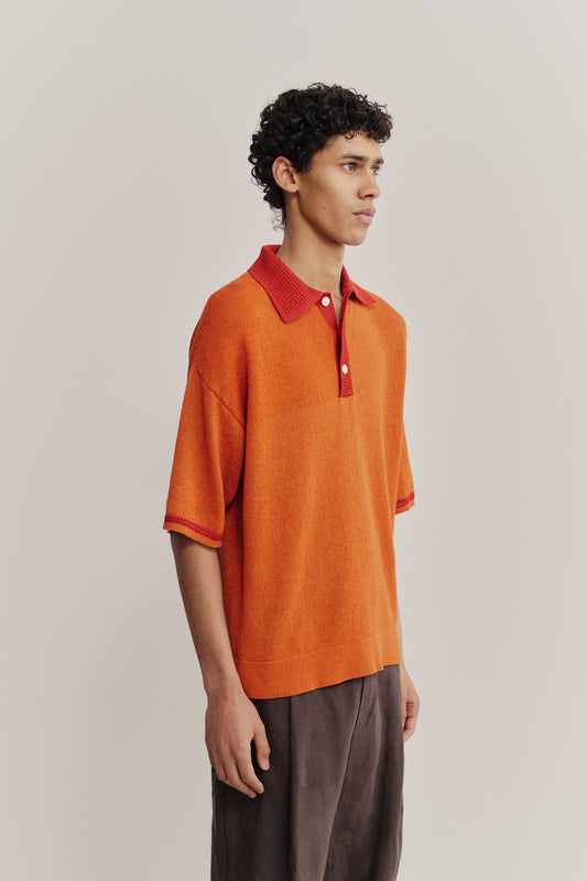 Men's knit short-sleeved polo, linen-organic cotton blend, orange with red contrast collar and sleeve stripe.