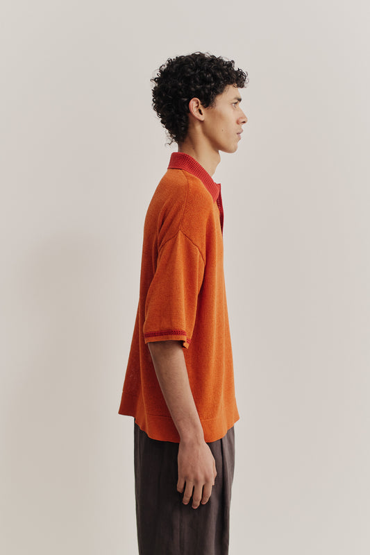 Men's knit short-sleeved polo, linen-organic cotton blend, orange with contrasting red collar and sleeve stripe.