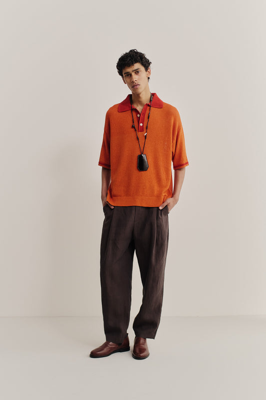 Men's knit short-sleeved polo, linen-organic cotton blend, orange with red contrast collar and sleeve stripe.