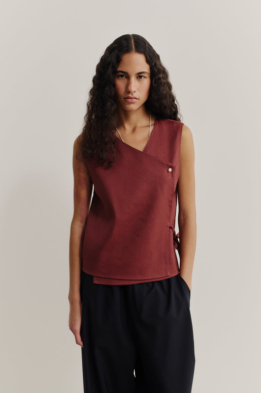 Women's sleeveless wrap shirt in linen-virgin wool-mohair blend, featuring an asymmetric front, V-neck, and button closure in dark red.