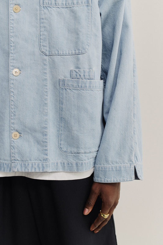 Men's long-sleeved overshirt, light blue cotton-silk denim with workwear patch pockets and natural buttons.