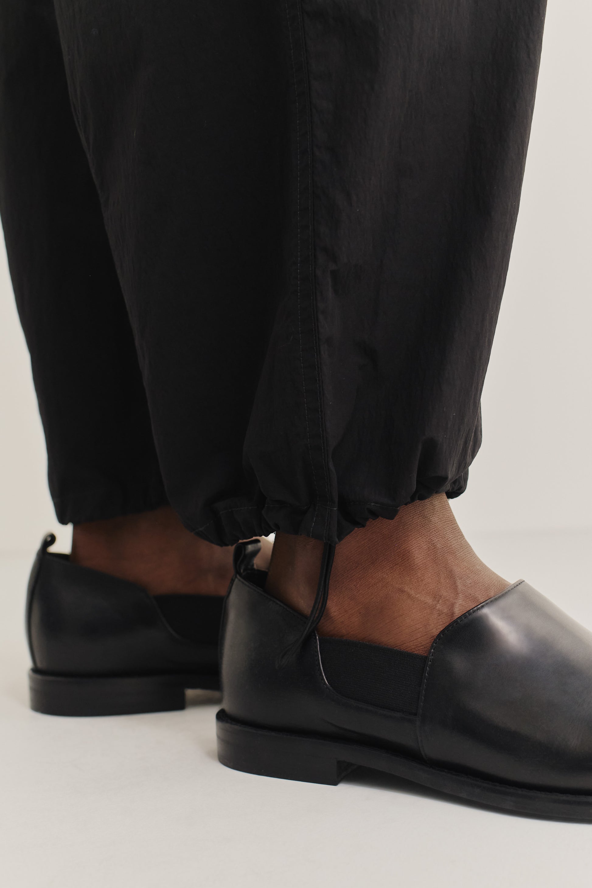 Men's long pants, recycled nylon and cotton blend, water-repellent, black, with elasticated ankles.