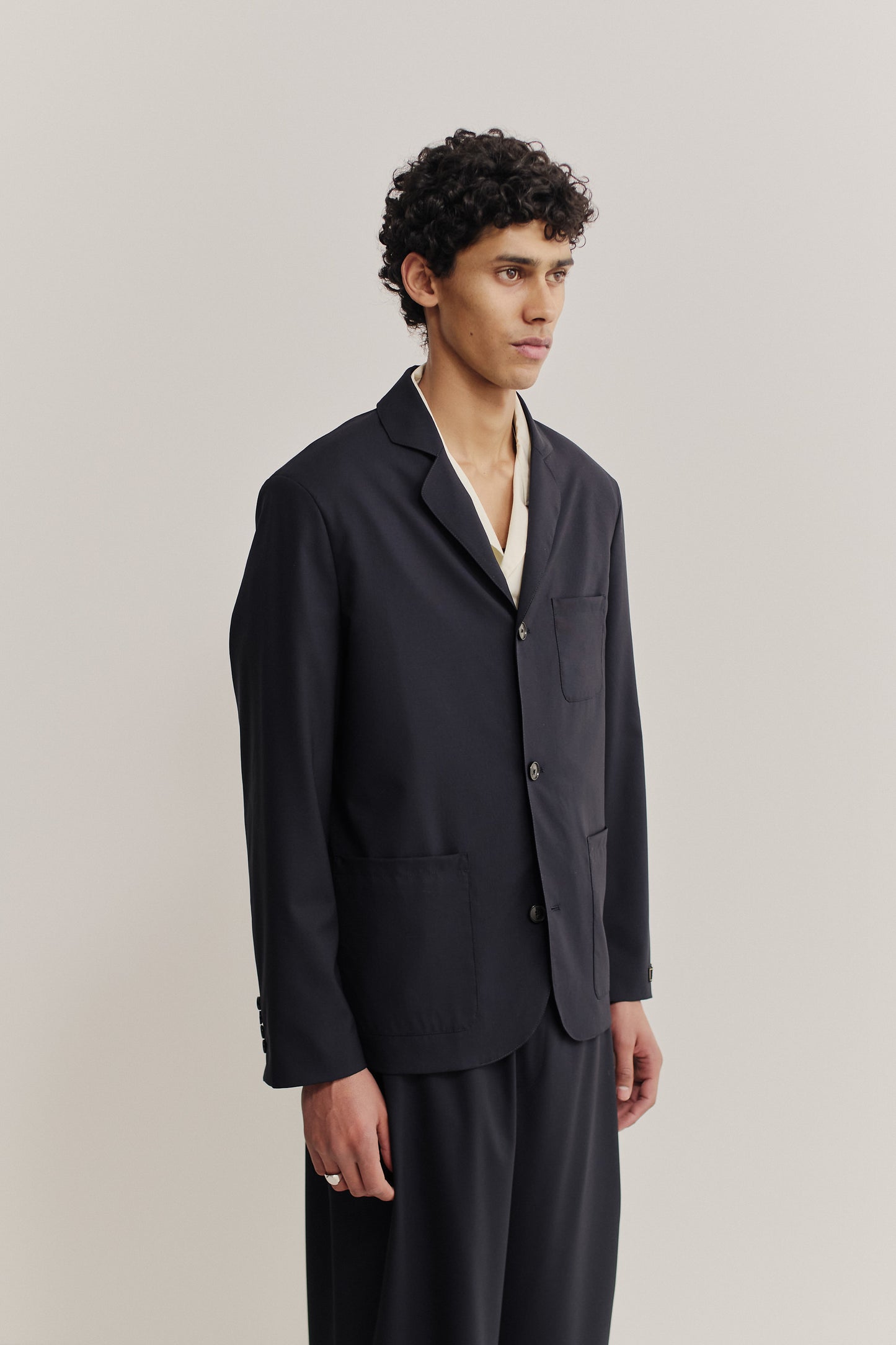 Men's tailoring, deconstructed atelier blazer, 100% virgin wool, dark navy, with three patch pockets and rounded lapel.