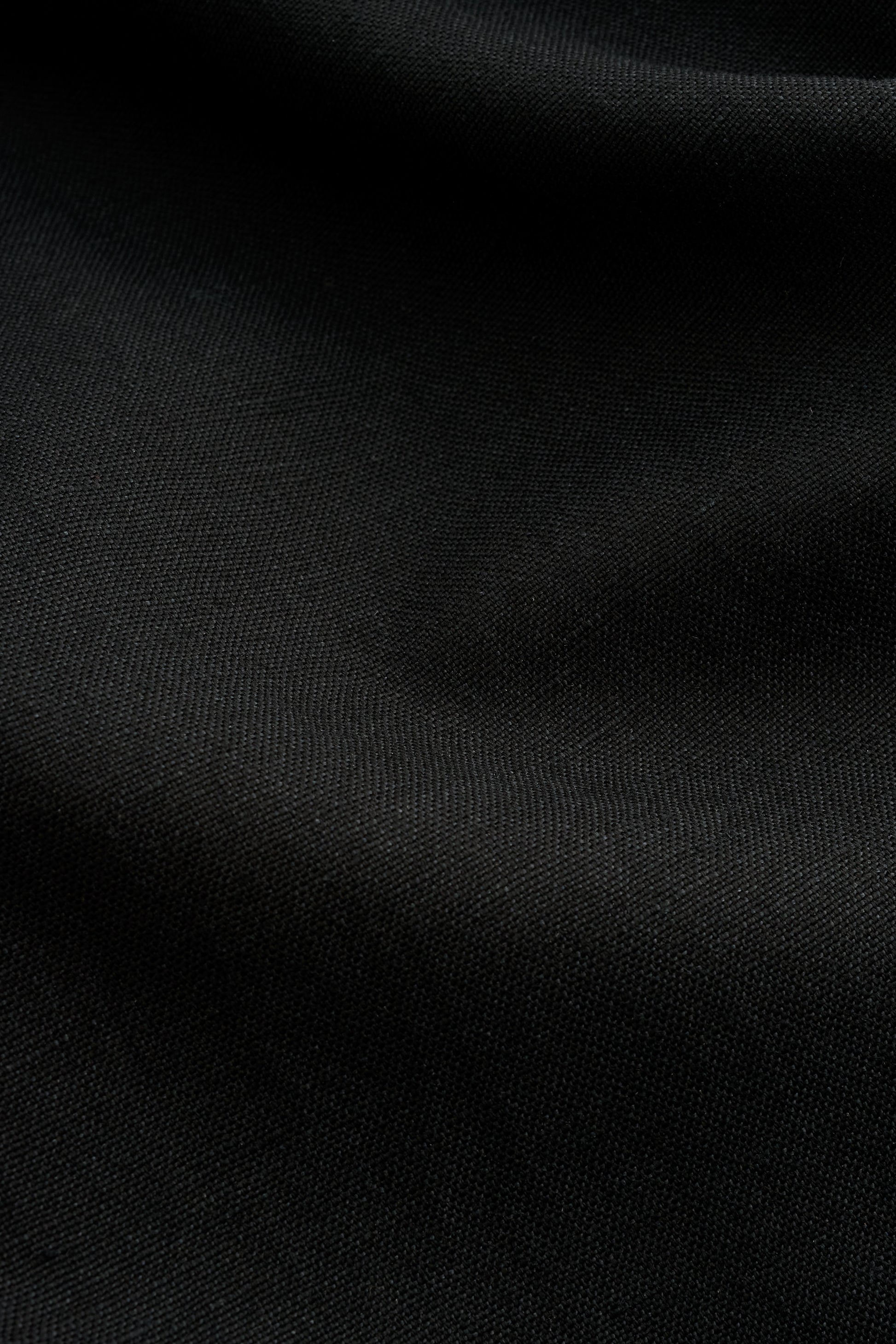 Women's dress, black worsted wool and linen blend fabric with subtle visual depth.