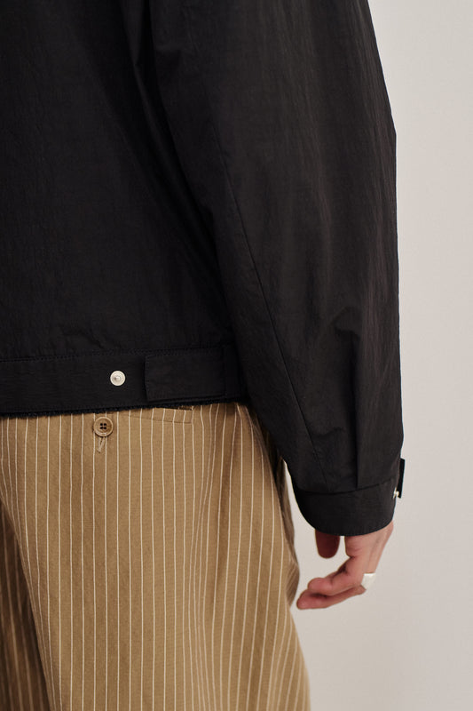 Men's outerwear jacket, black recycled nylon cotton blend, with elasticated waist and front zip.