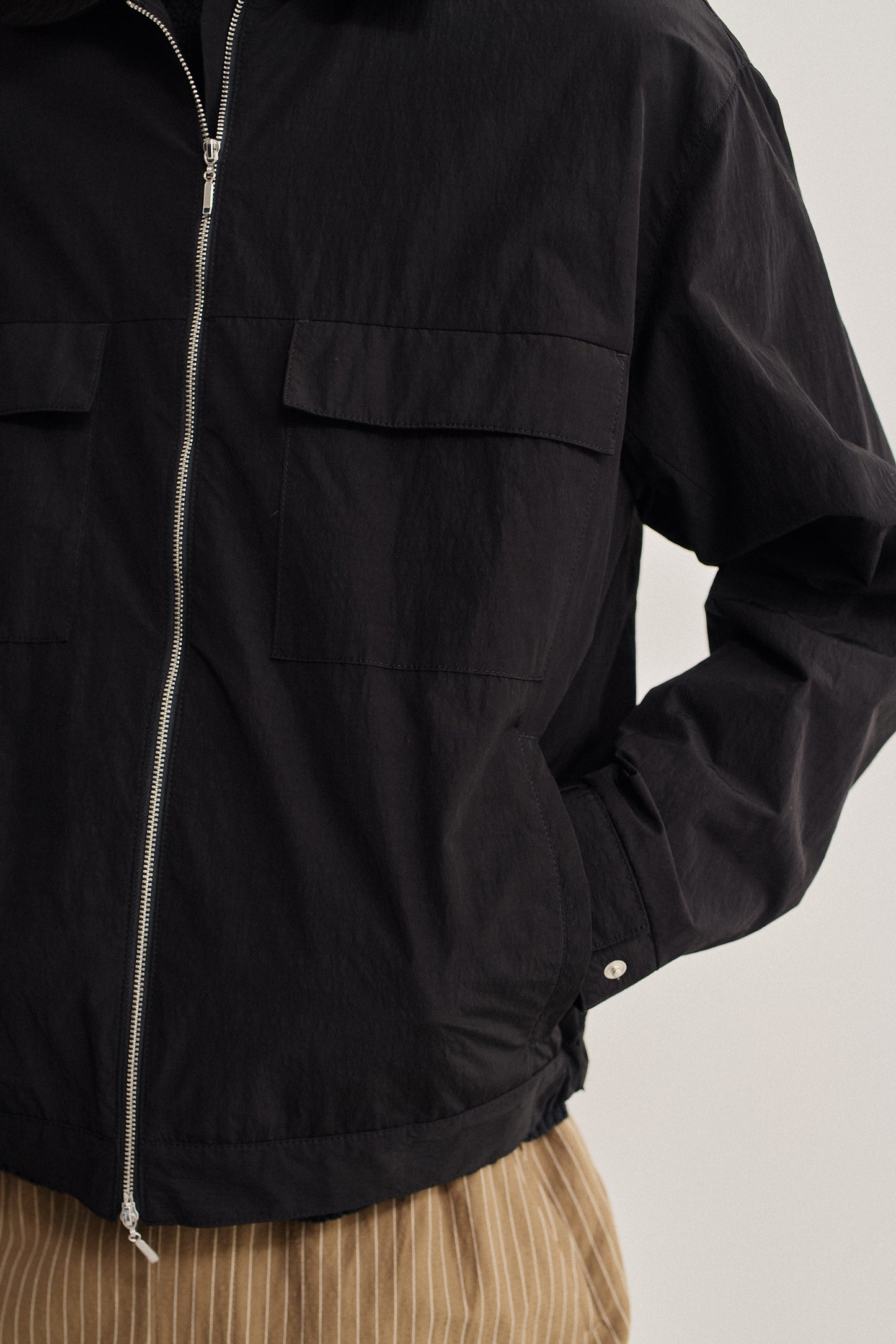 Men's outerwear jacket, black recycled nylon cotton blend, water-repellent, with flap chest pockets and front zip.
