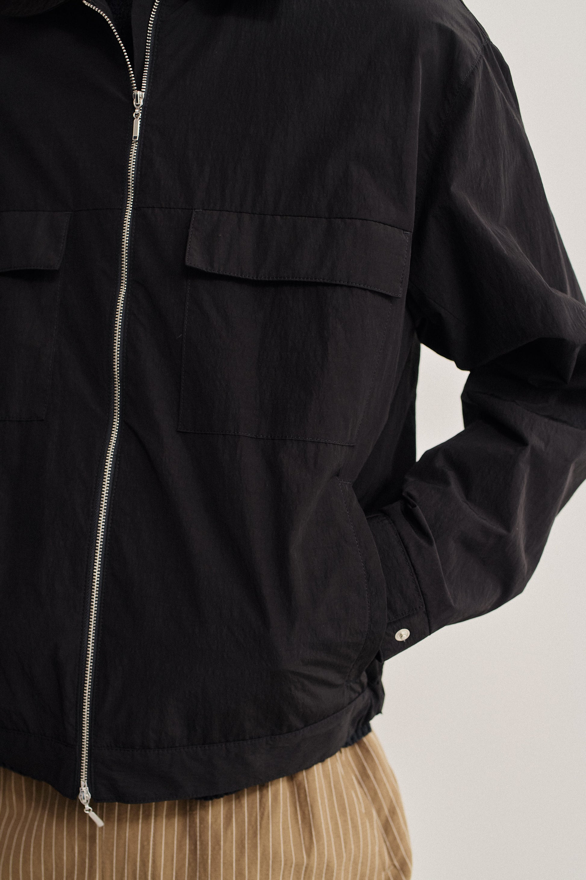 Men's outerwear jacket, black recycled nylon cotton blend, water-repellent, with flap chest pockets and front zip.