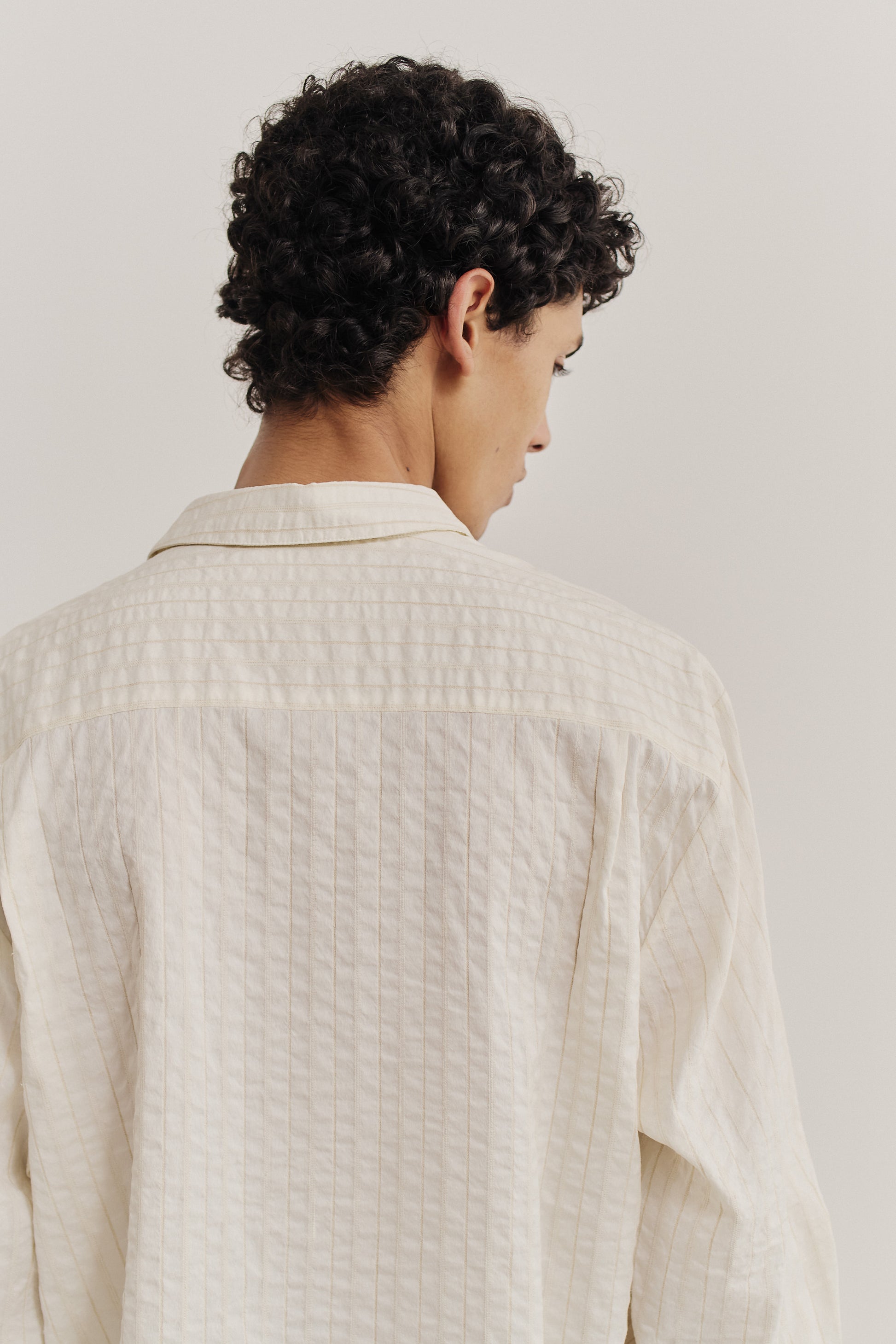 Men's long-sleeved shirt, cotton-silk-linen blend, washed, off-white with subtle striped texture.