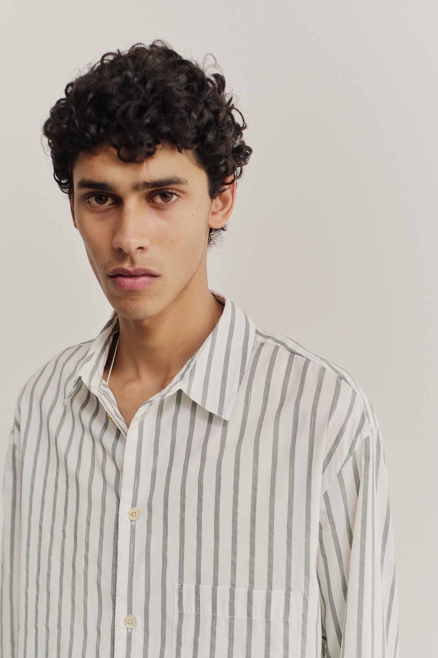 Men's long-sleeved shirt, cotton-silk-linen blend, washed finish, white with subtle green stripes, oversized fit.