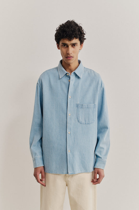 Men's long-sleeved shirt, organic cotton denim, washed light blue with white pinstripes, oversized fit, patch pocket.