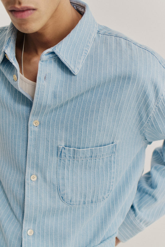 Men's long-sleeved shirt, light blue washed organic cotton denim with white pinstripes and front patch pocket.