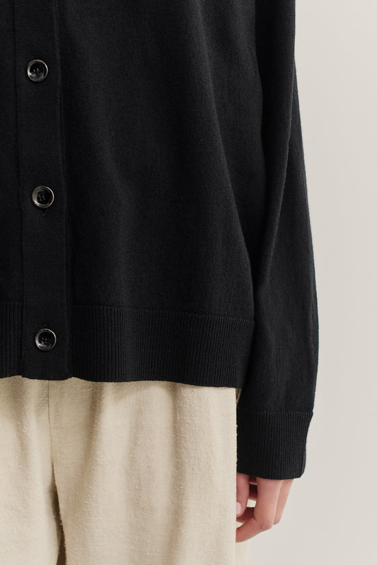 Women's knit cardigan, 100% merino wool, black, with button closure and ribbed trims.