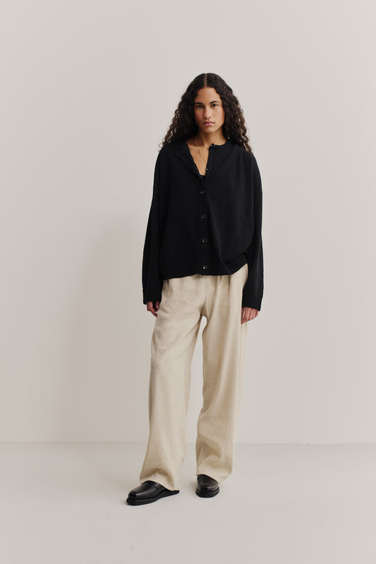 Women's knit cardigan, 100% merino wool, black, relaxed fit with dropped shoulders and deep V-neck.