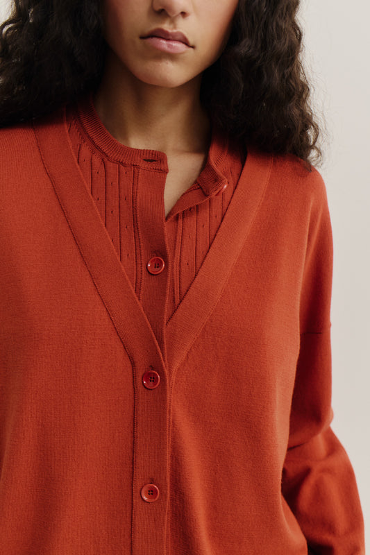 Women's knit cardigan, 100% merino wool, terracotta, with mock underlayer and ajour knit pattern.