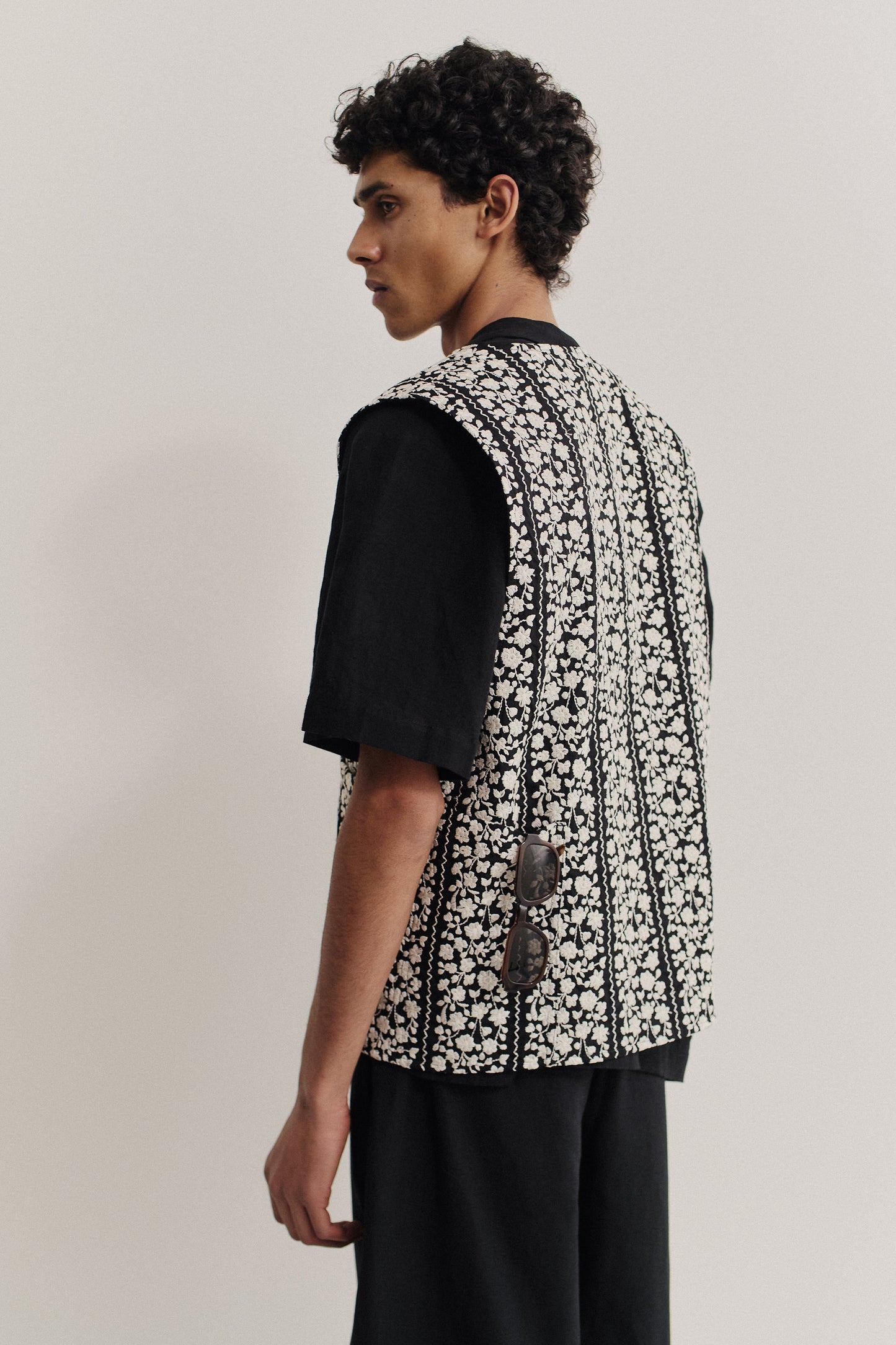 Men's outerwear vest, black cotton with embroidered white flower blocks, metal zipper, oversized fit.