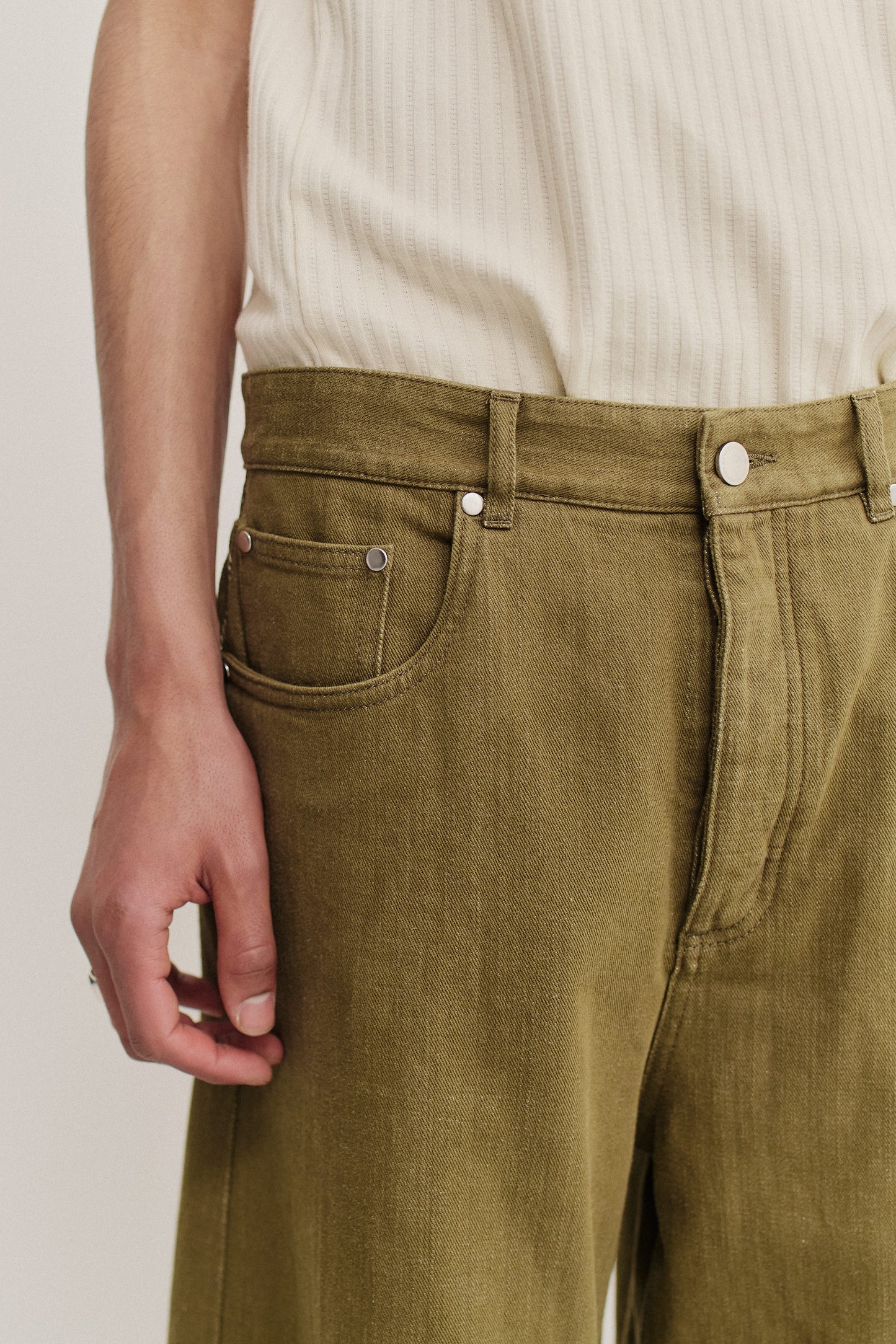 Men's long-pants, cotton selvage denim, washed olive green, with silver hardware and a relaxed fit.