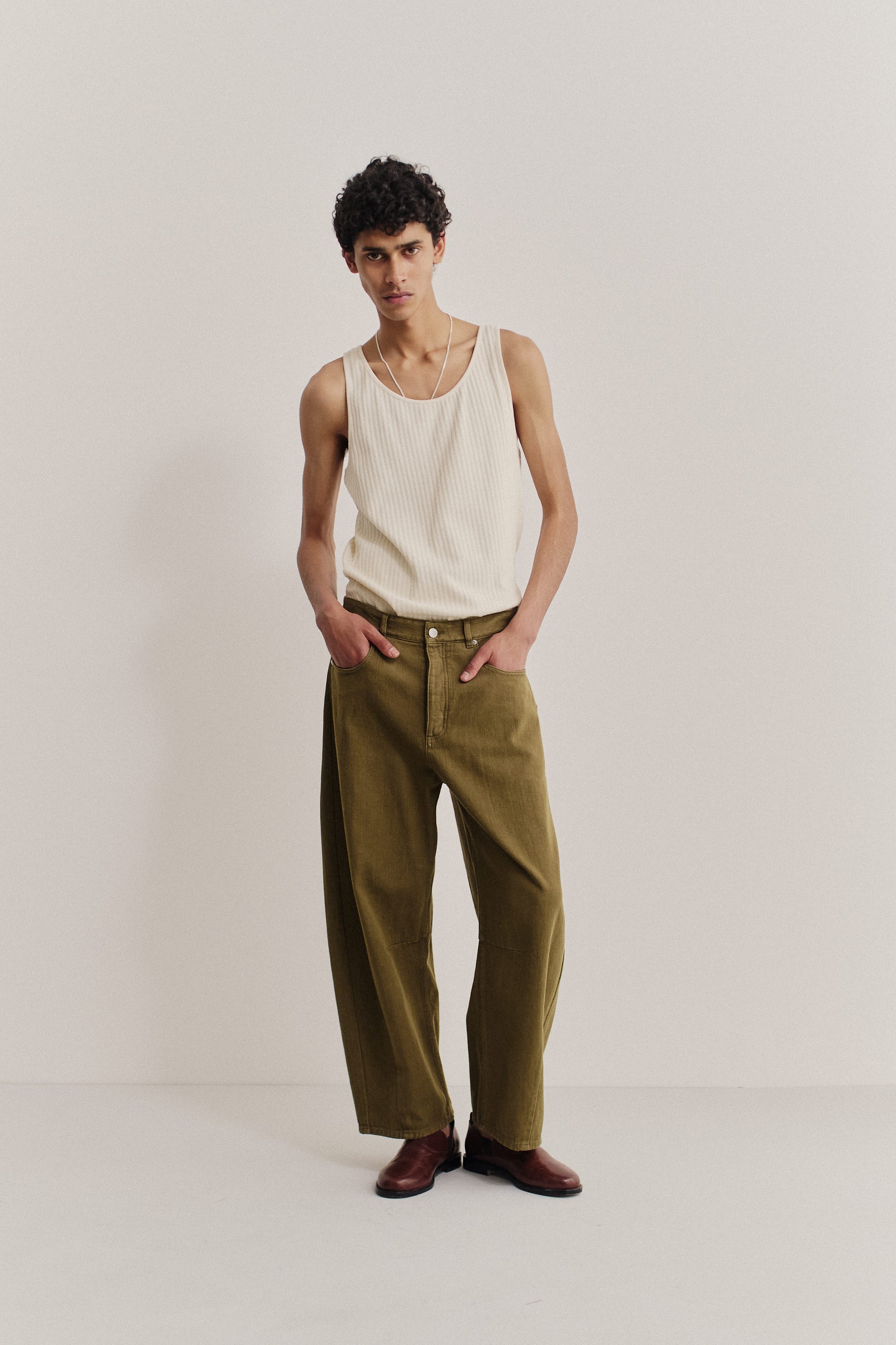 Men's long-pants, cotton selvedge denim, olive green, wide-cropped tapered leg, worn by a model.