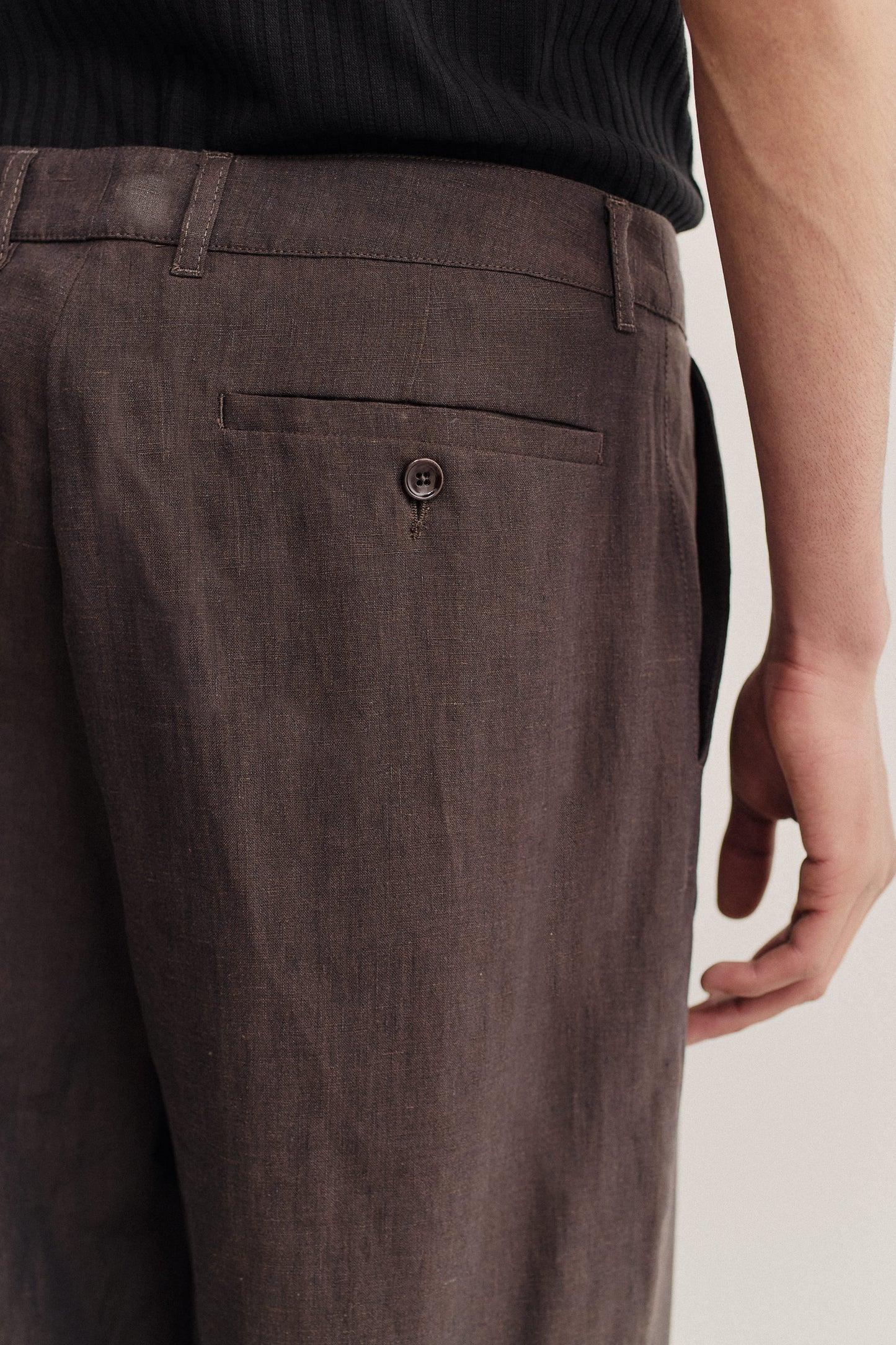 Men's long-pants, 100% linen, canvas weave, dark brown, with a single back buttoned pocket.