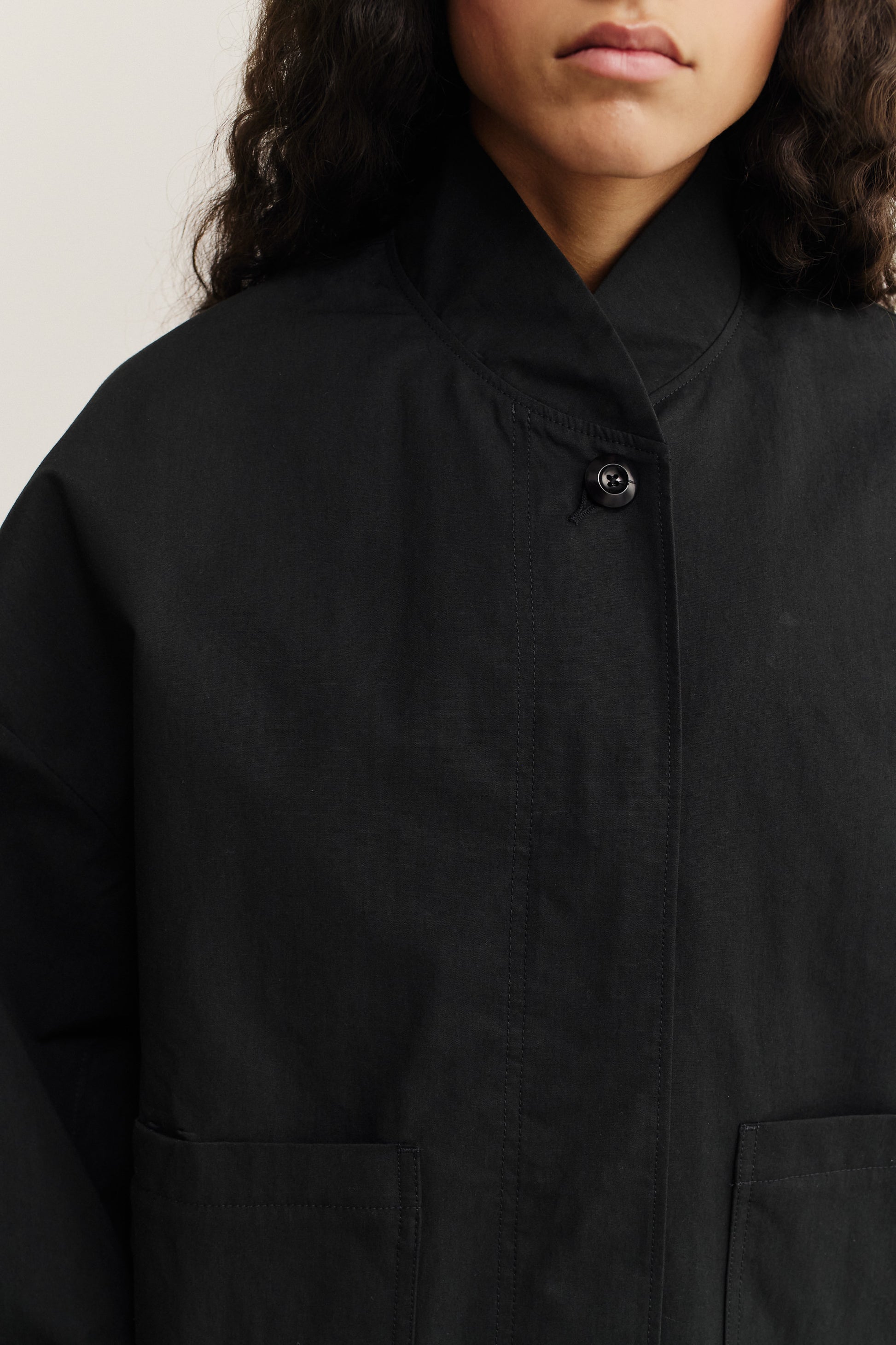 Women's outerwear, black cotton blend jacket with stand collar and patch pockets.