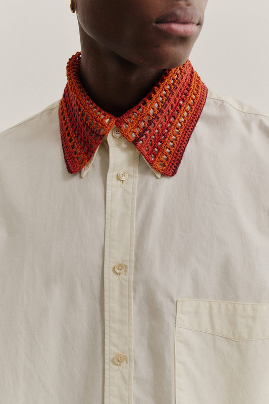 Women's accessory, hand-crocheted Kikoy Collar in red-orange merino wool, over a light linen-cotton shirt.