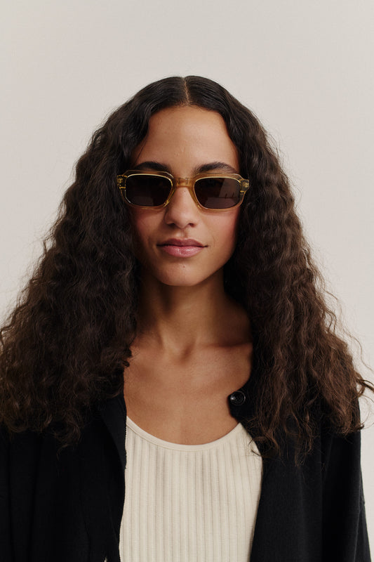 Women's accessories sunglasses, acetate, rectangular, translucent amber frame, dark lenses.