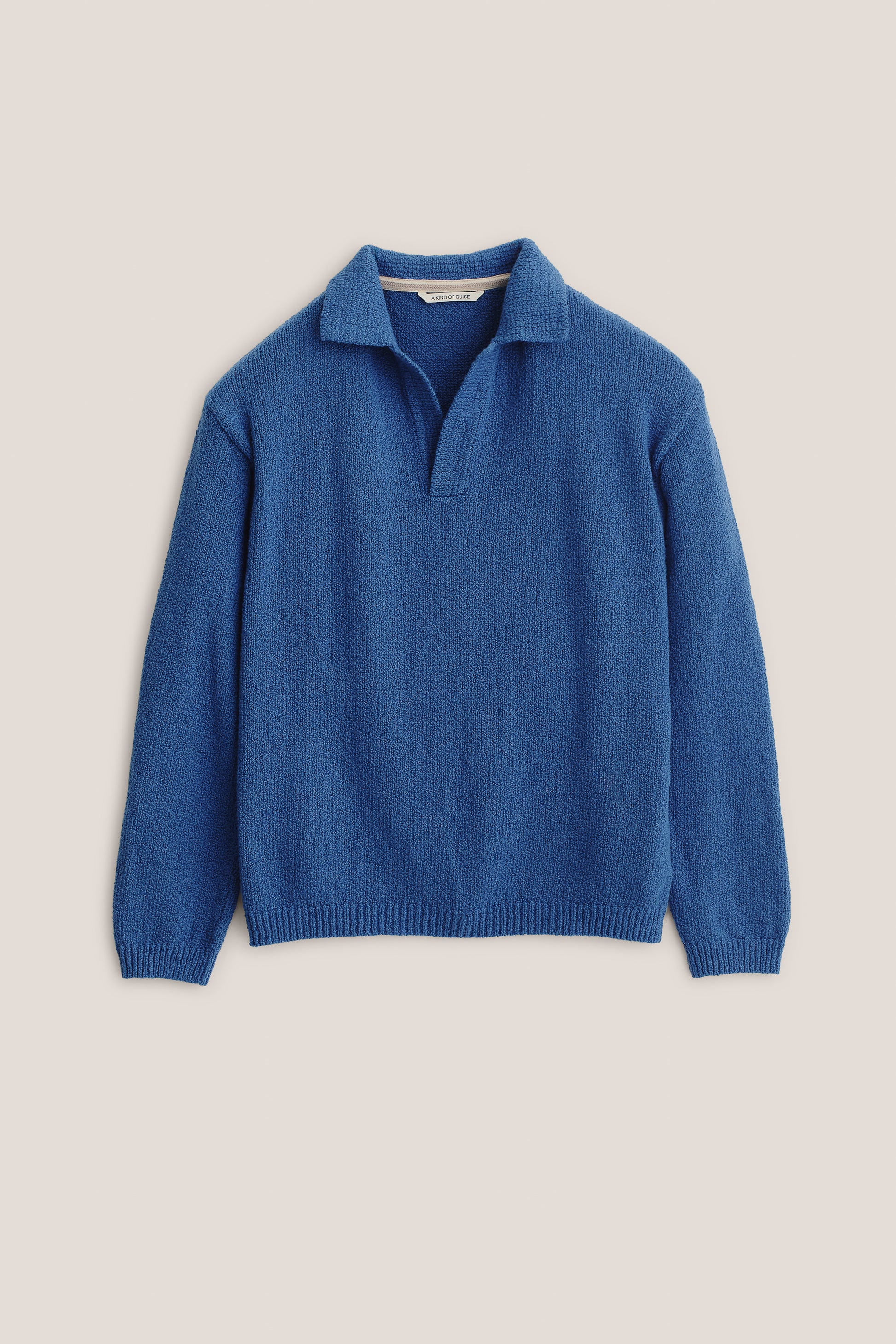 Men's knit long-sleeved polo, organic cotton bouclé, blue, with open collar and ribbed trims.