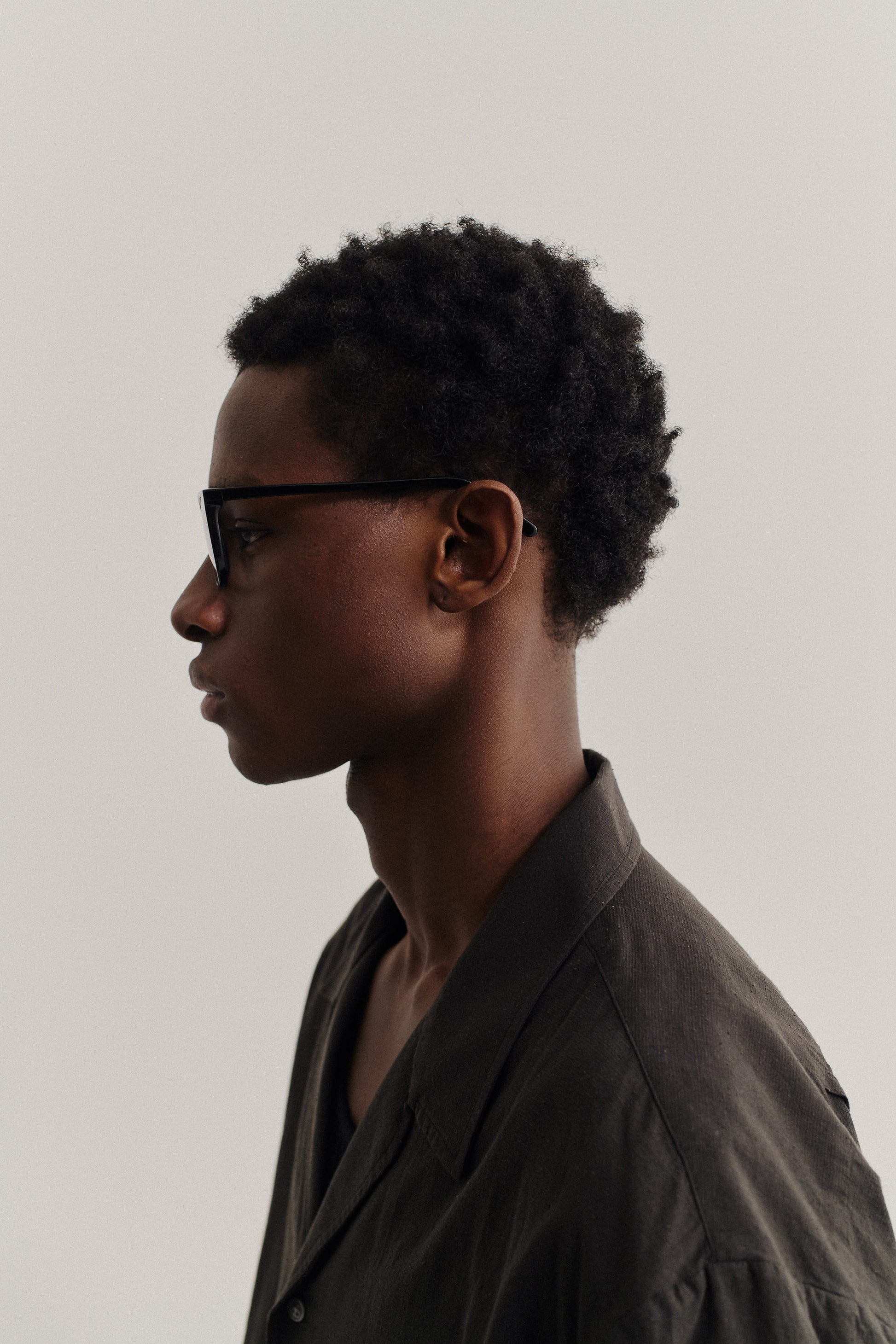 Men's accessories, black acetate MARSEILLE sunglasses with dark lenses, worn by a man in a dark linen shirt.