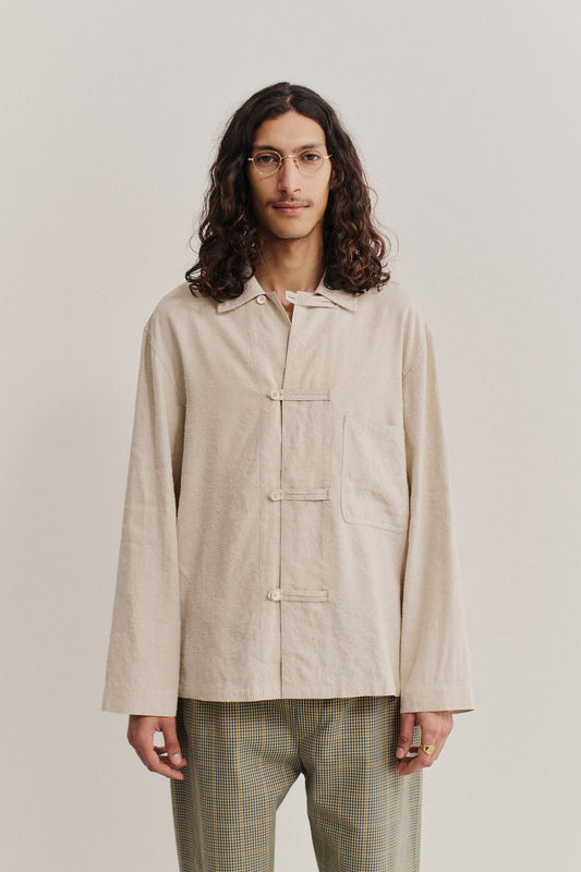 Men's long-sleeved overshirt, linen-silk blend, undyed natural texture, oversized fit with patch pocket and frog button fastening.