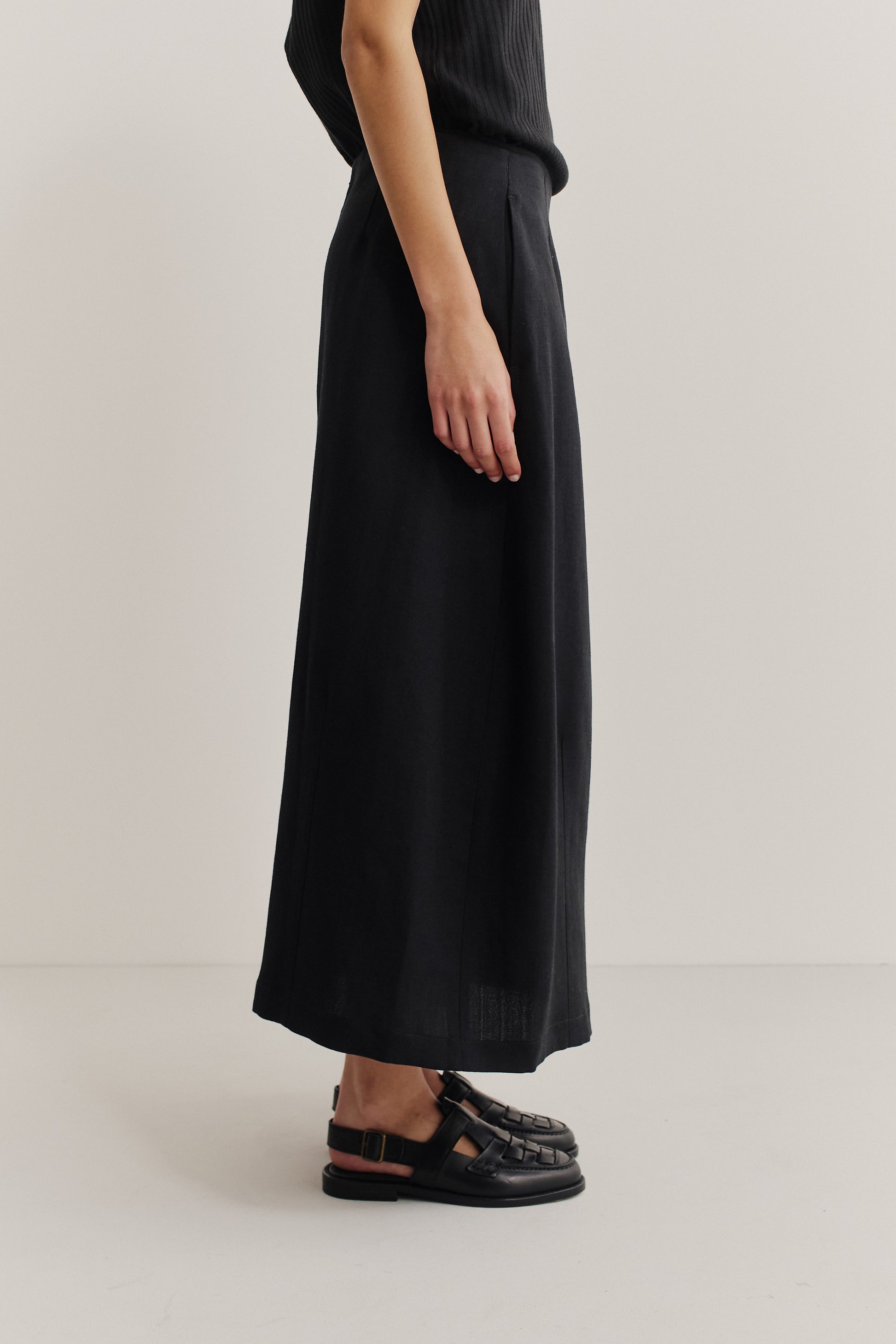 Women's midi skirt, black worsted wool and linen blend, o-shaped silhouette with side pockets.
