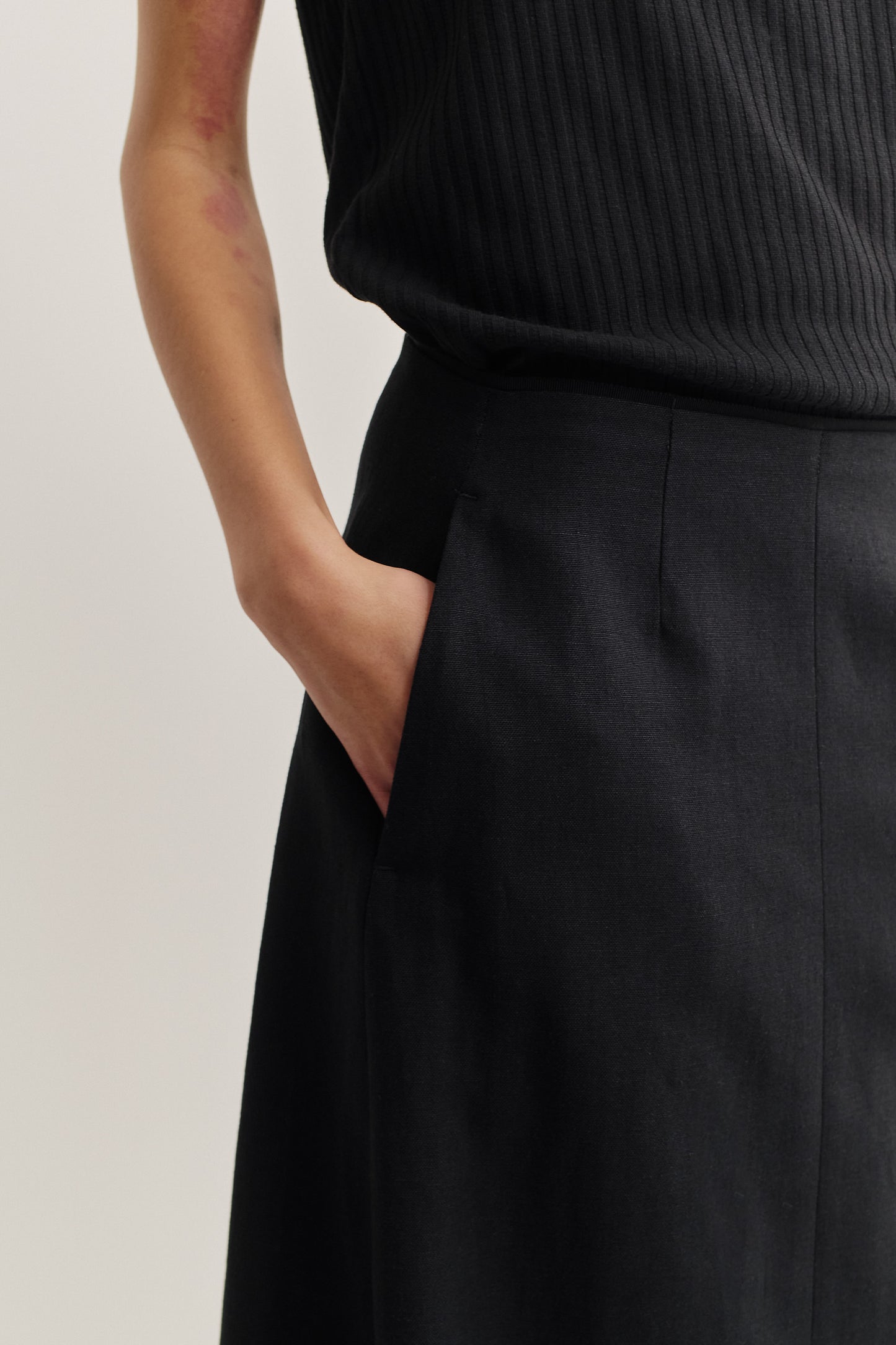Women's midi skirt, worsted wool and linen blend, black, o-shaped silhouette with side seam pockets.