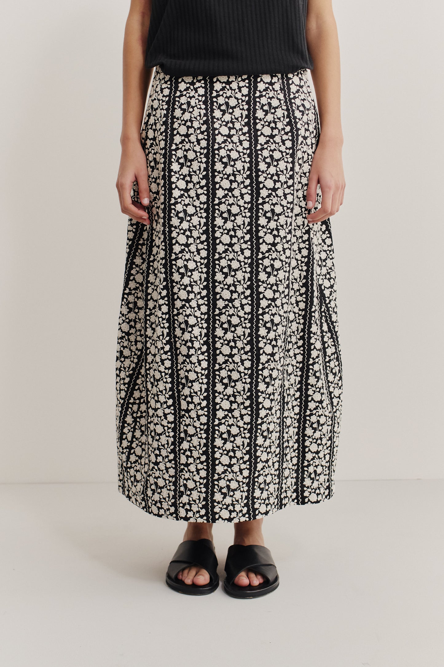 Women's skirt, midi-length, 100% cotton, black with white embroidered floral blocks, o-shaped silhouette.