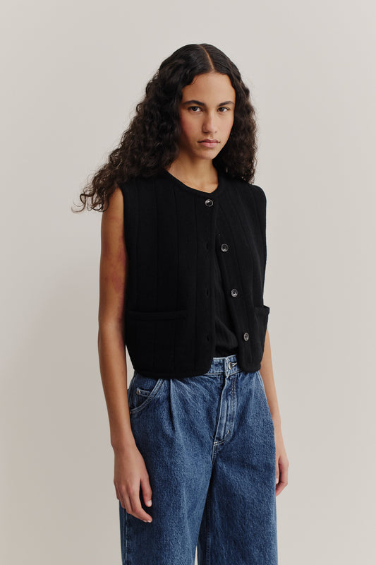 Women's knit vest, black 100% merino wool, ajour knit pattern, button-front, cropped, worn with blue jeans.