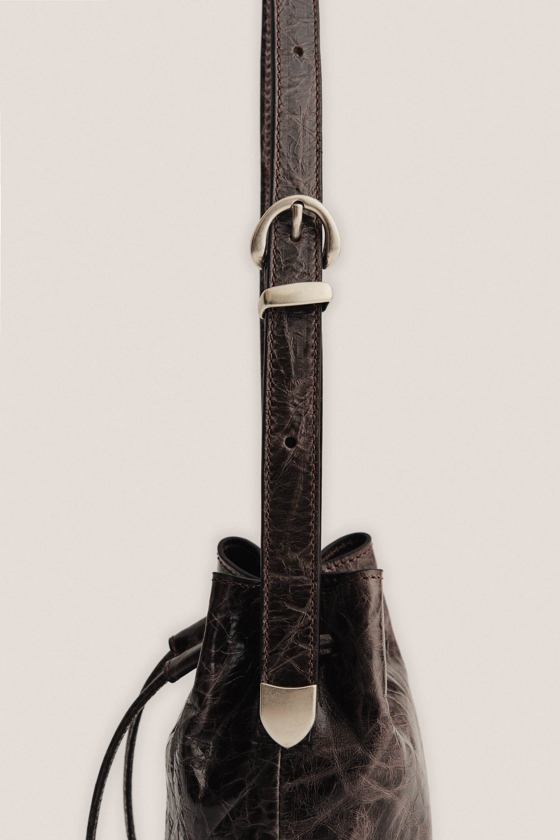 Women's accessories mini round bucket bag, dark brown lwg-certified calf leather with silver buckle.