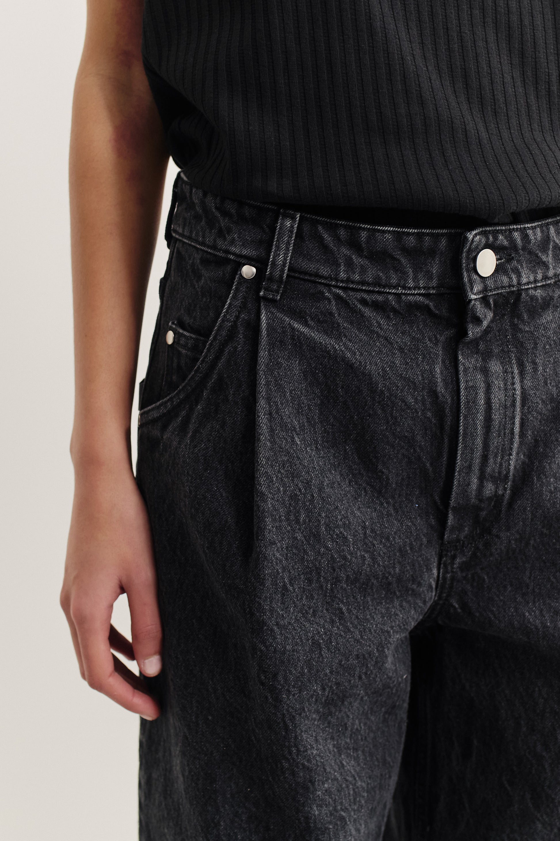 Women's long pants, organic cotton denim, stone washed, dark grey, with pleat detail and mid-waist fit.