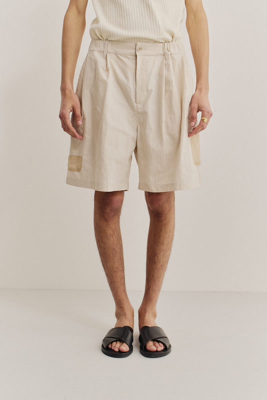 Men's shorts, cotton blend ripstop, waxed finish, beige, with front pleats and mesh patch pockets.