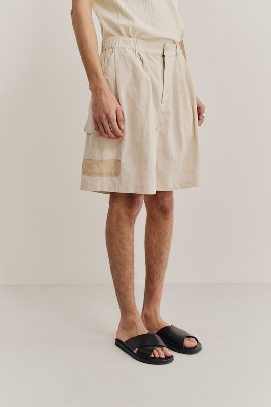 Men's shorts, cotton blend ripstop, waxed finish, beige, with elastic waist, front pleats, and side patch pockets.