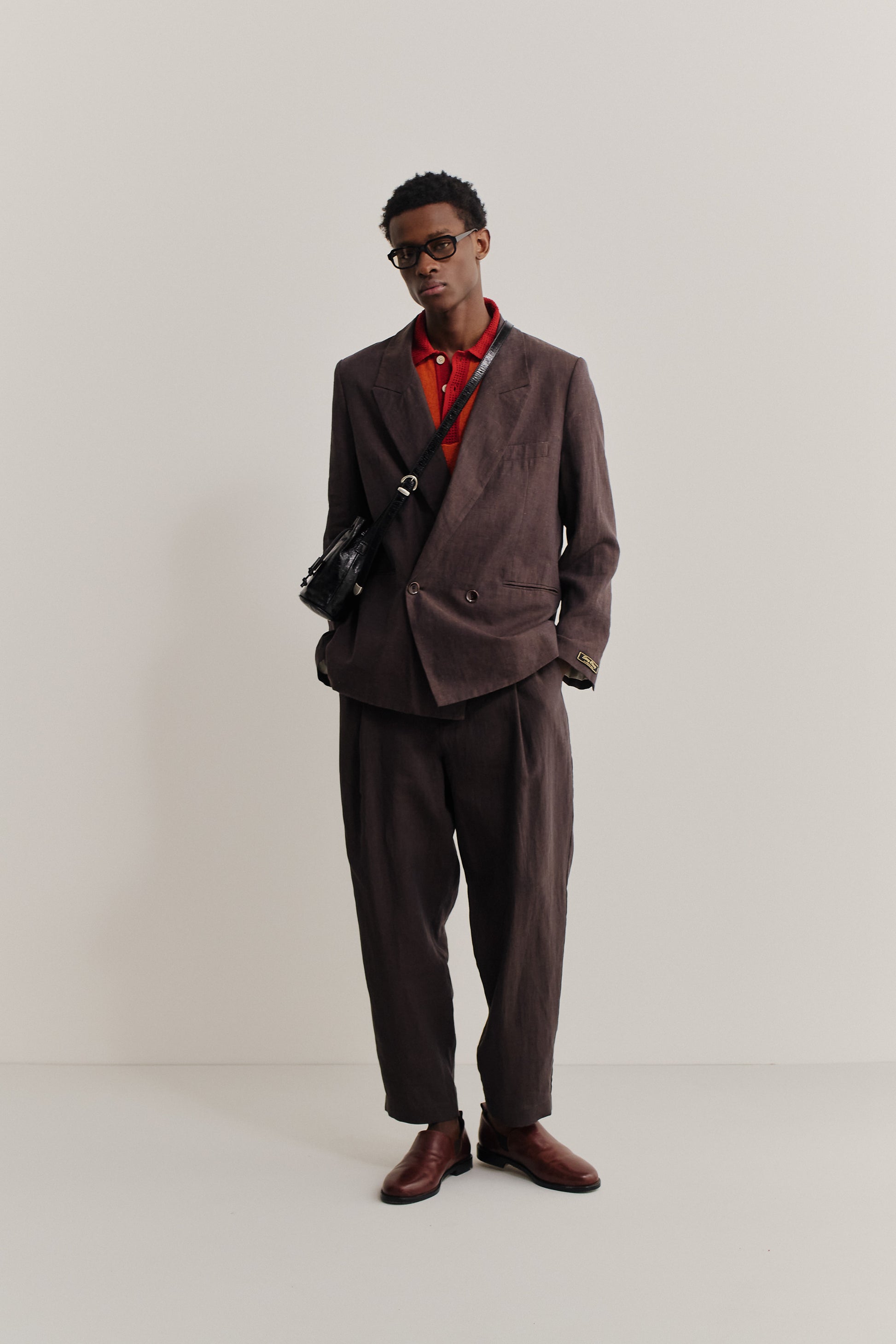Men's tailoring, linen, burnt umber, relaxed double-buttoned blazer and trousers with red polo.