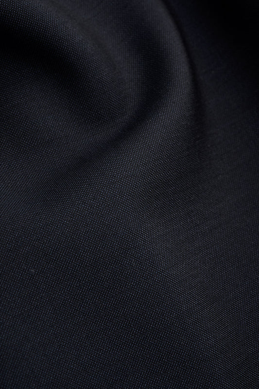 Men's long pants, virgin wool, dark navy, close-up of fabric texture.