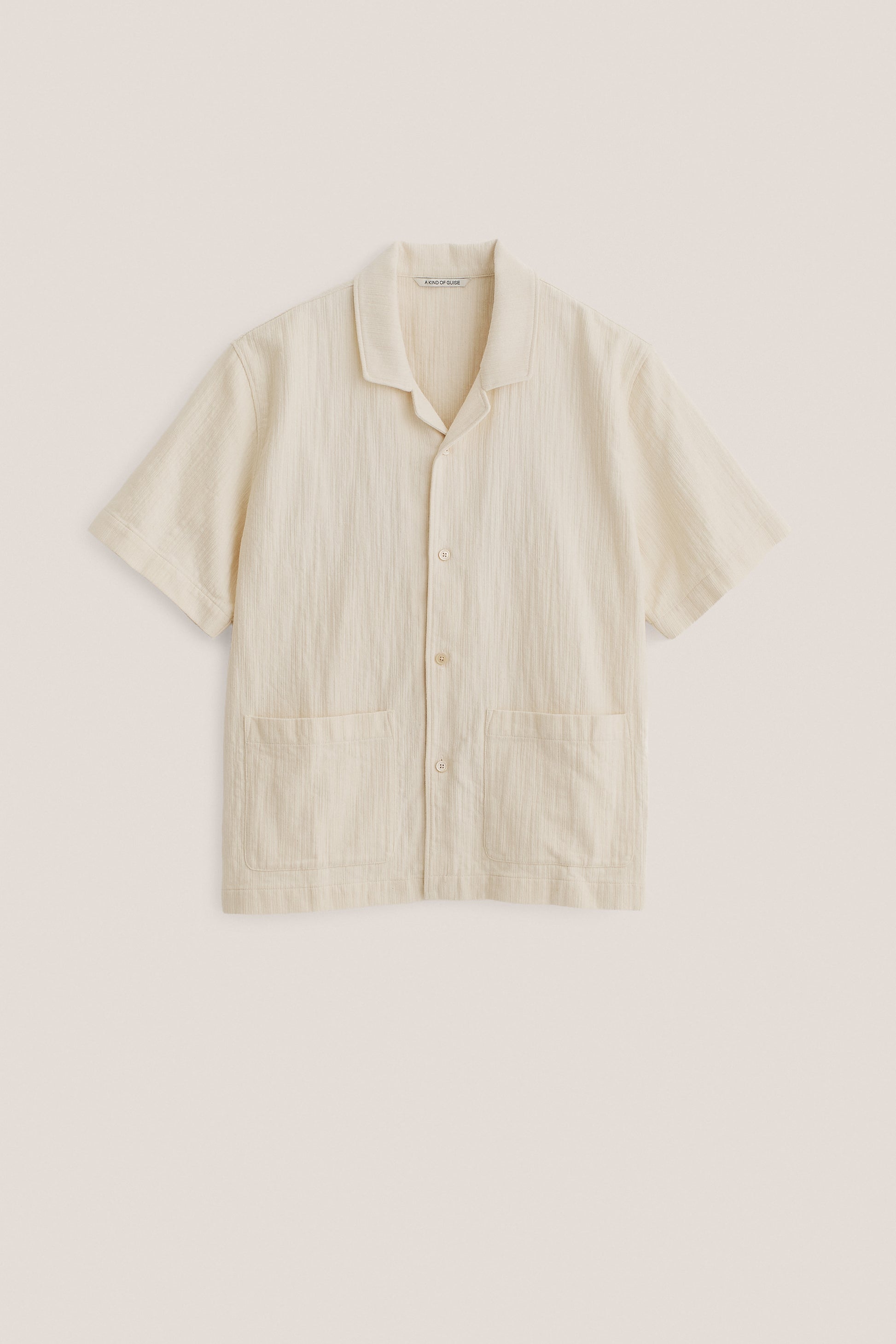 Men's short-sleeved shirt in textured recycled cotton mix, plain off-white, with spread collar and double patch pockets.
