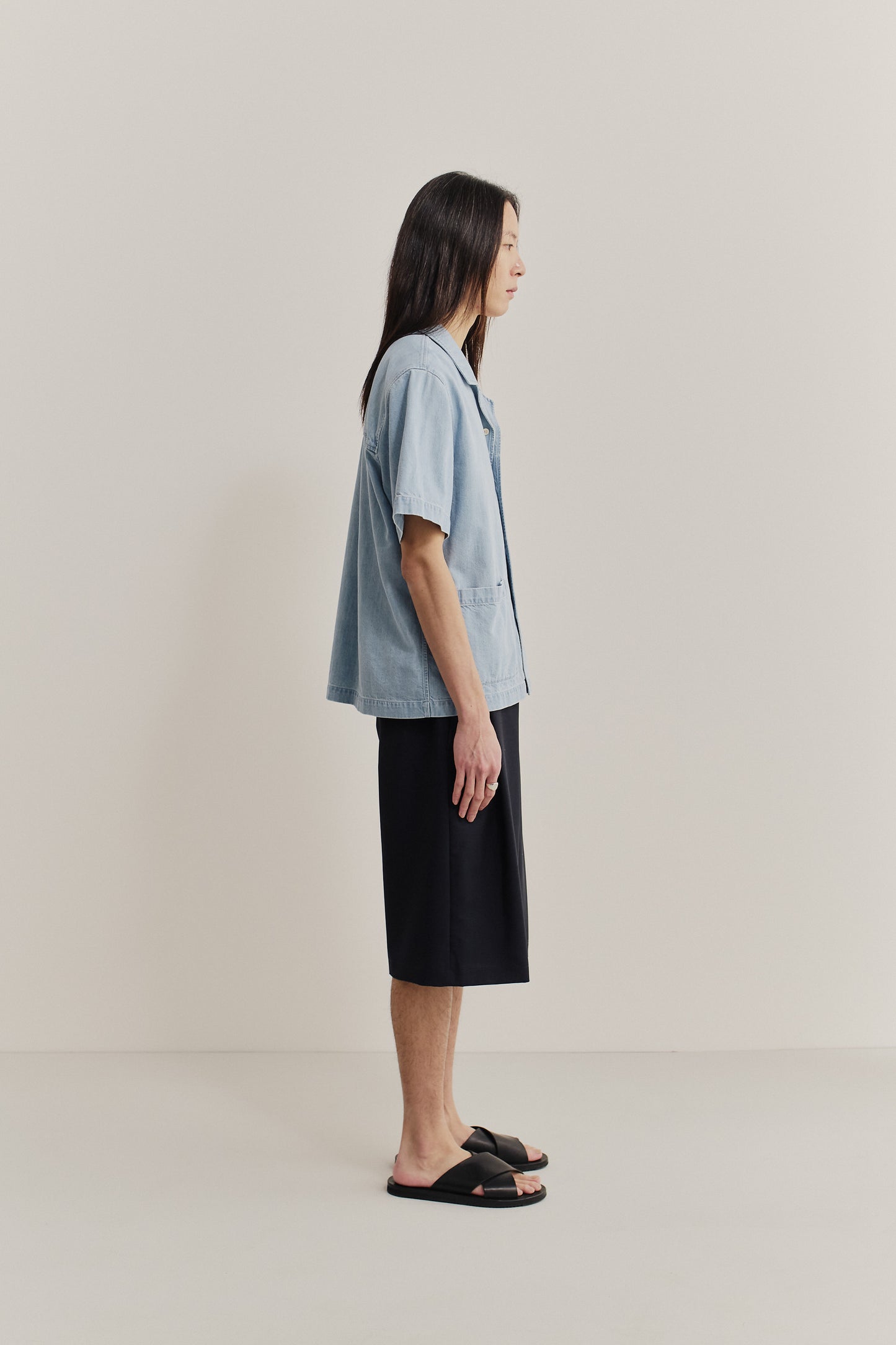 Men's short-sleeved shirt in light blue cotton-silk denim with rounded collar and double patch pockets.
