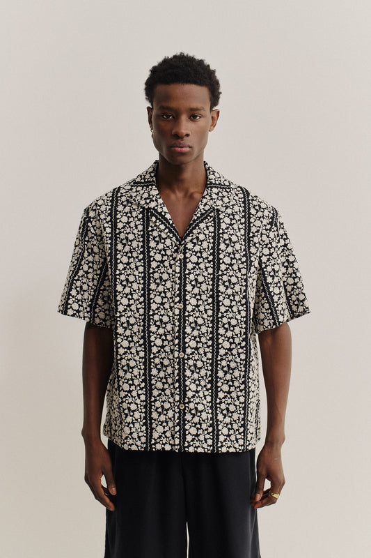 Men's short-sleeved shirt, 100% cotton, black with white embroidered floral blocks, notched collar.