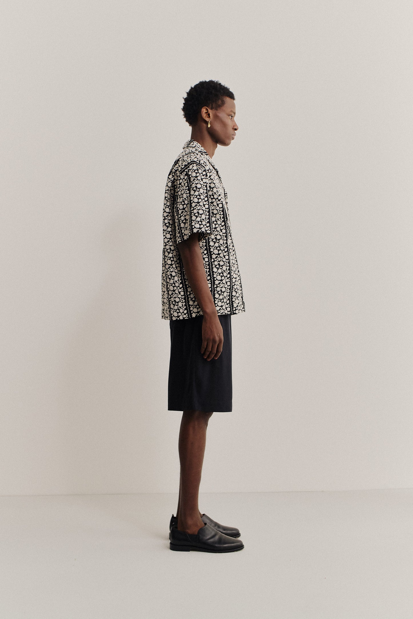 Men's short-sleeved shirt, 100% cotton, black with white embroidered flower blocks, notched collar, relaxed fit.