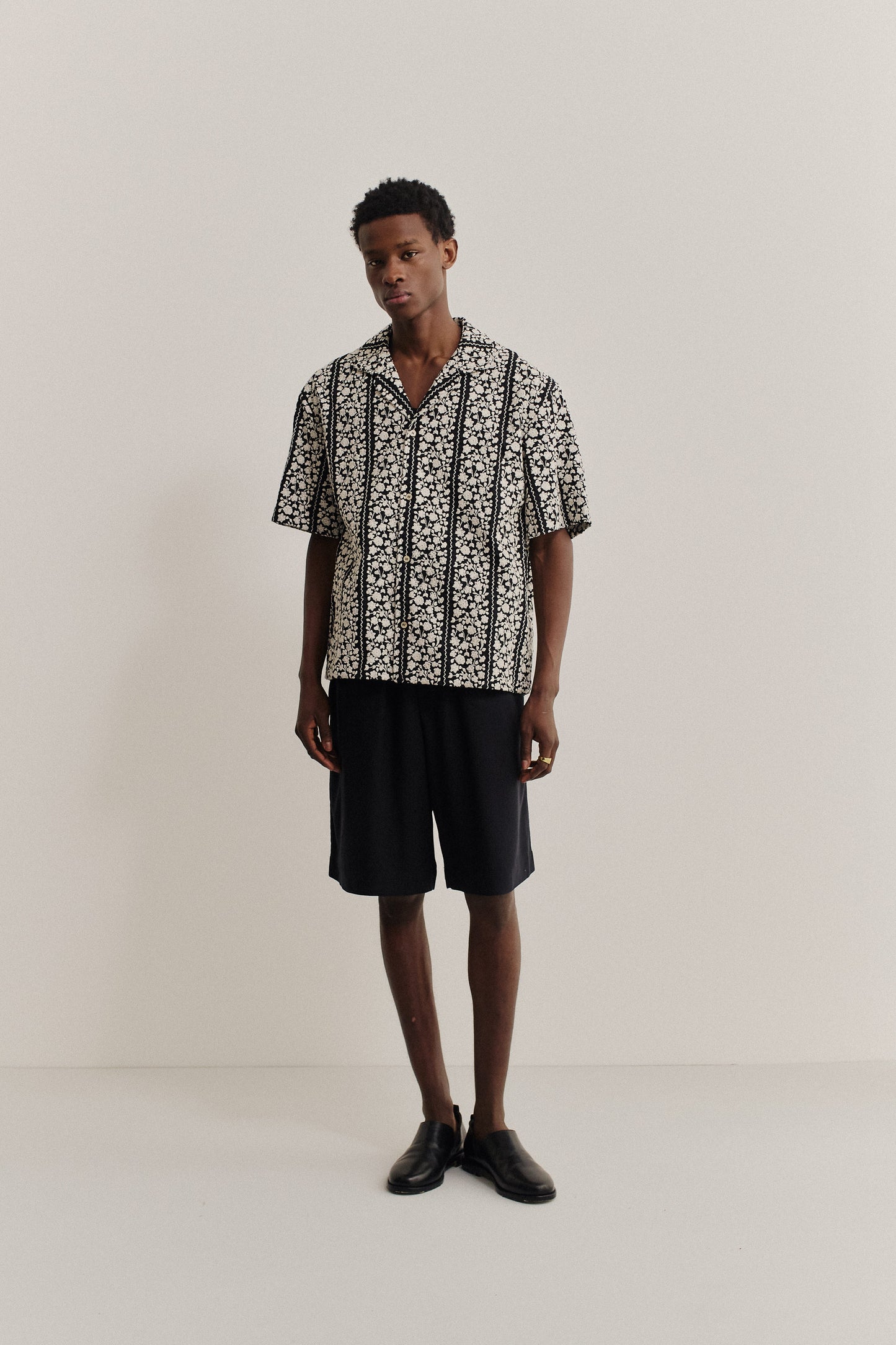 Men's short-sleeved shirt, 100% cotton, black with white embroidered floral blocks, notched collar.