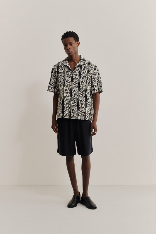 Men's short-sleeved shirt, 100% cotton, black with white embroidered floral blocks, notched collar.