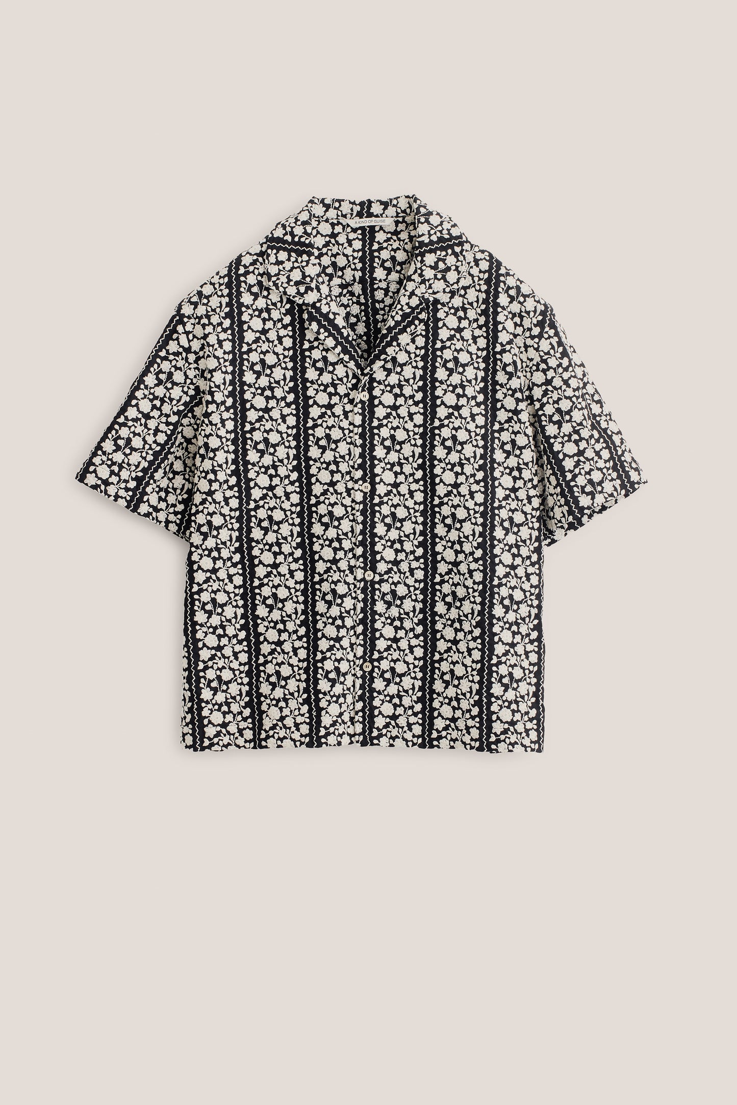 Men's short-sleeved shirt, 100% cotton, black with embroidered white flower blocks and wavy lines.