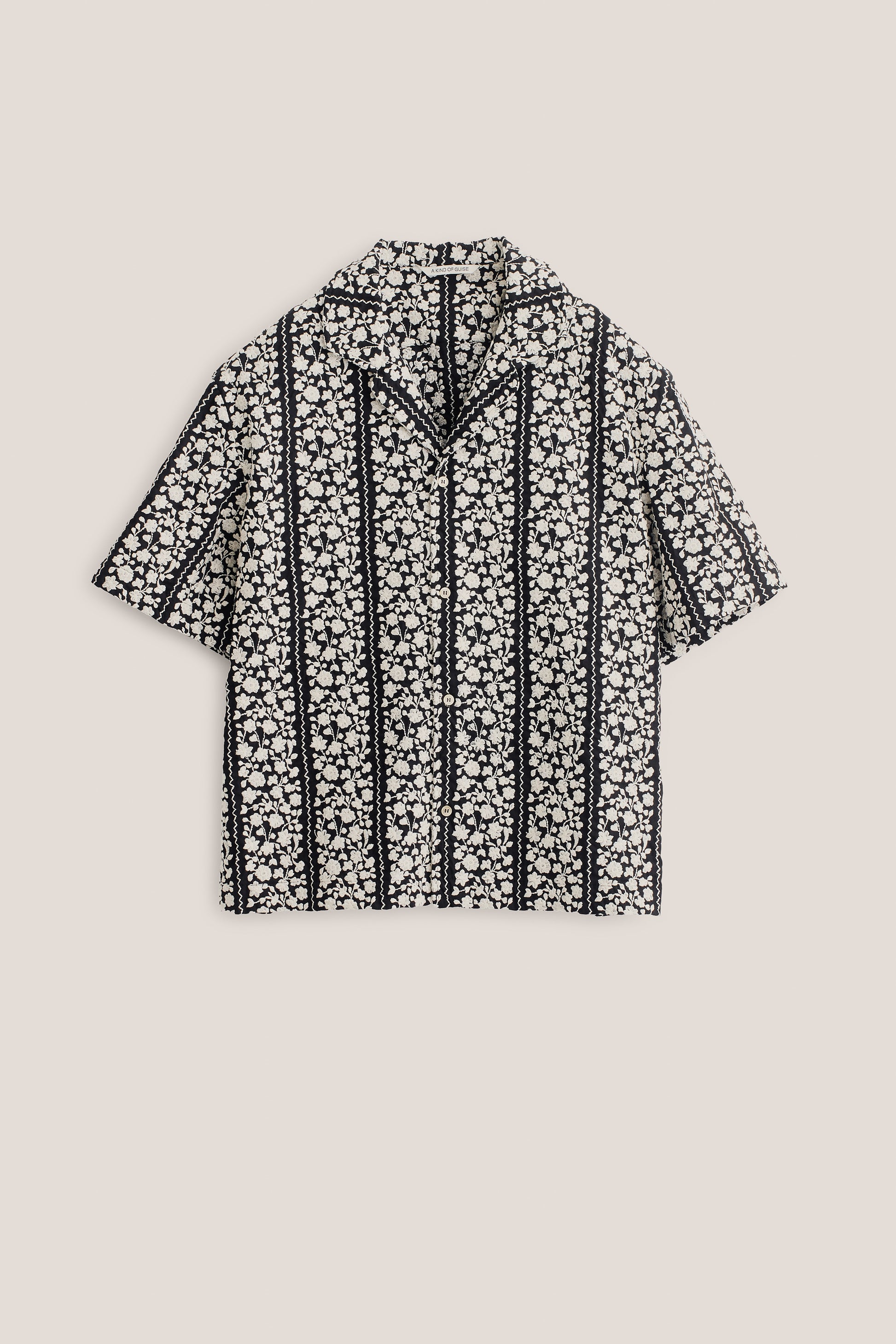 Men's short-sleeved shirt, 100% cotton, black with embroidered white flower blocks and wavy lines.