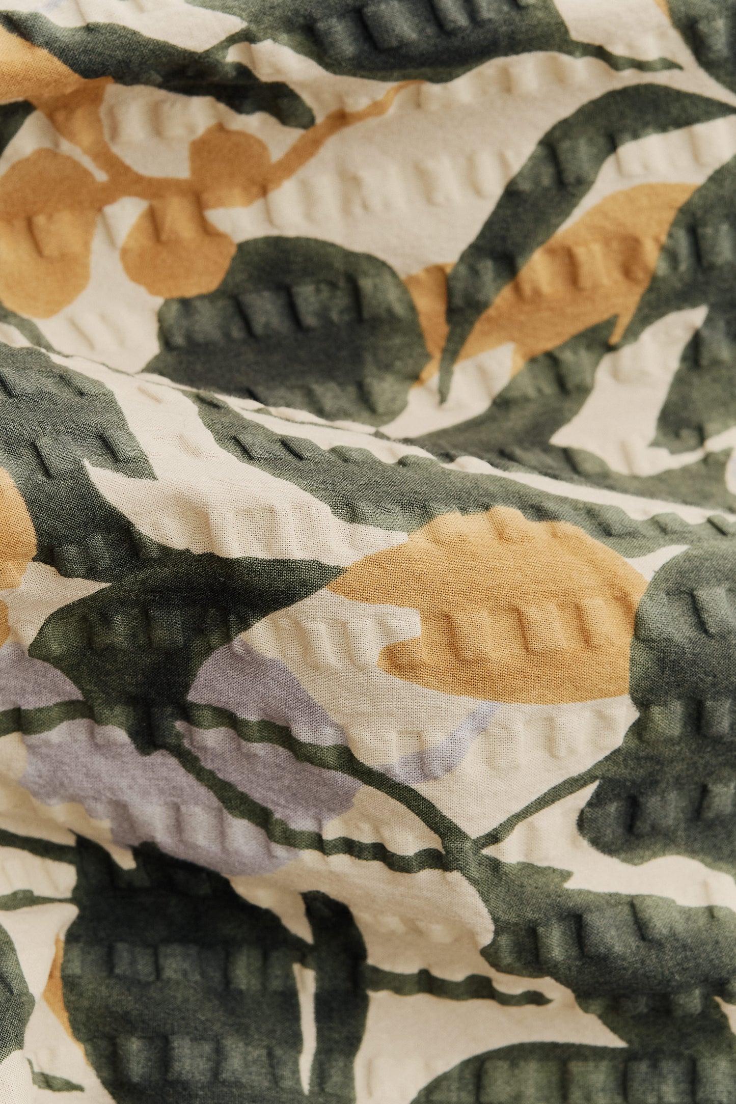 Men's short-sleeved shirt in Japanese cotton seersucker with a beige, green, and yellow floral pattern.