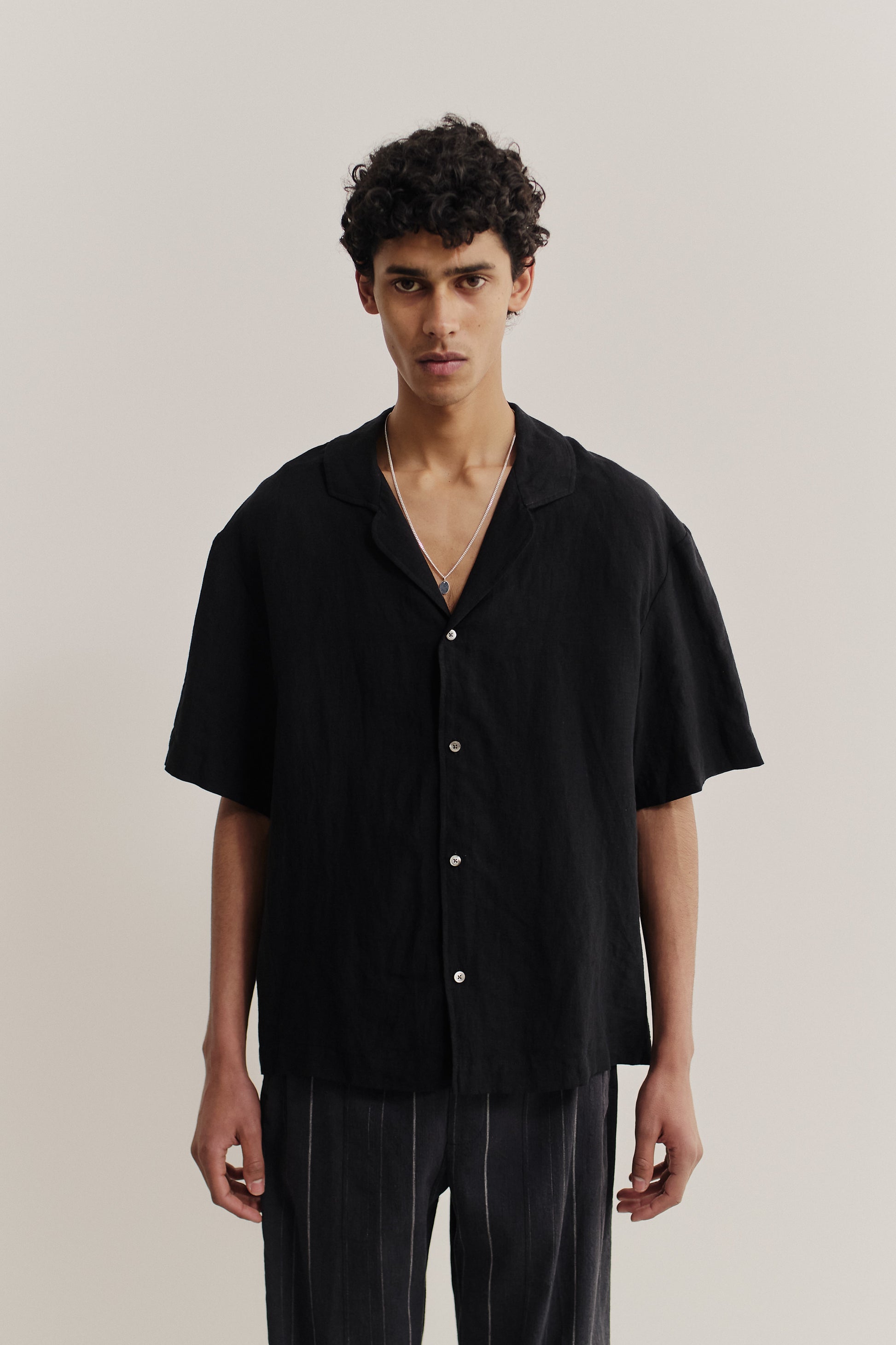 Men's short-sleeved shirt, 100% linen, natural black, with notched collar and dropped shoulders.