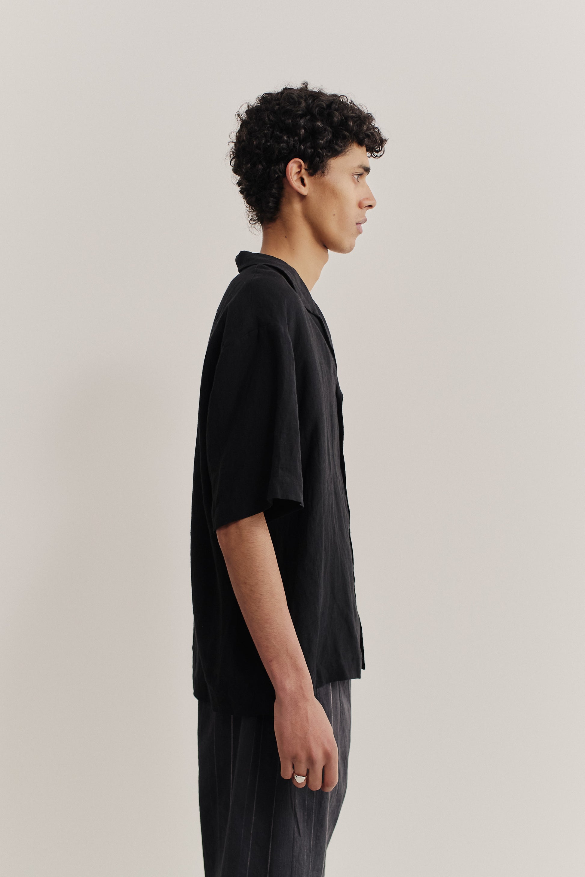 Men's short-sleeved shirt, 100% linen, natural black, with notched collar and dropped shoulders.